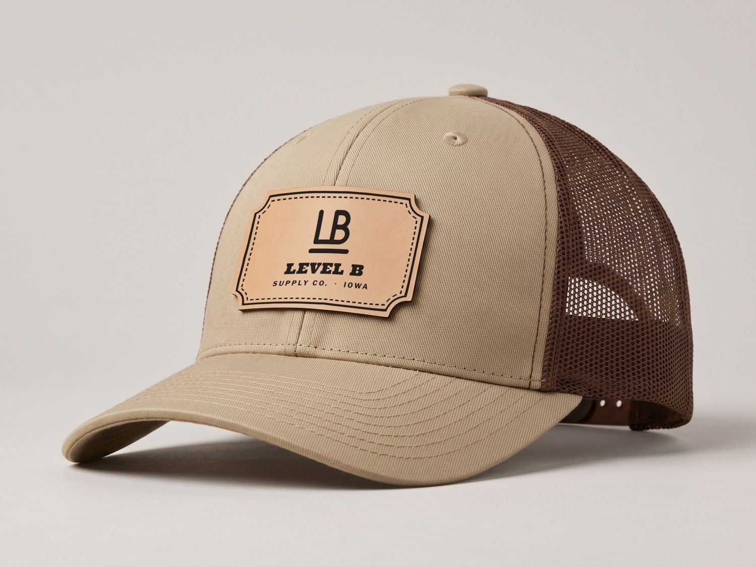 Khaki and coffee trucker hat with the Level B rawhide leather patch